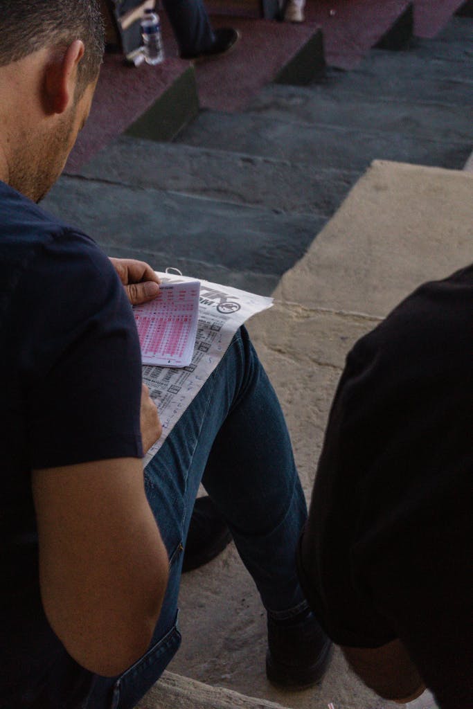 Person reviewing betting slips at a stadium — capturing the decision-making behind top sports betting books.  